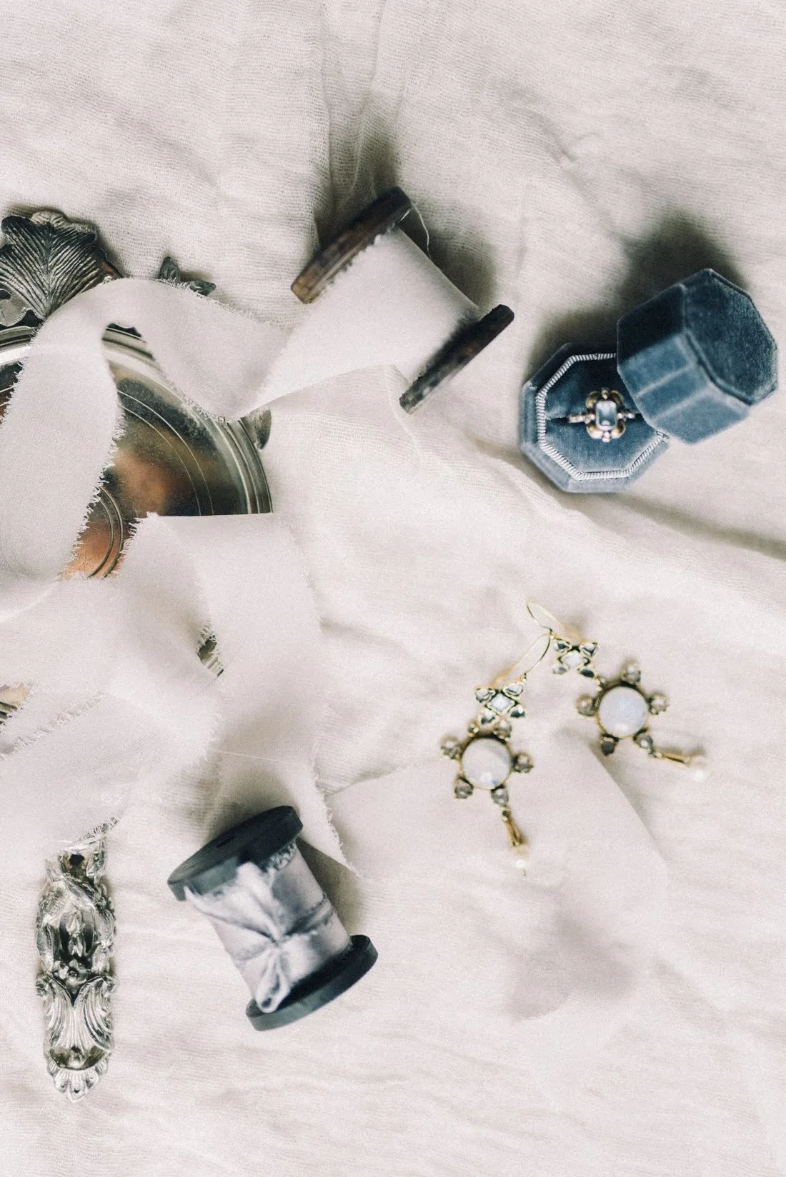Aretes y anillos dispuestos sobre una tela blanca.